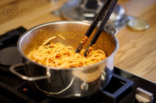 Selbst gemachtes Pesto Rosso unter Spaghetti geben